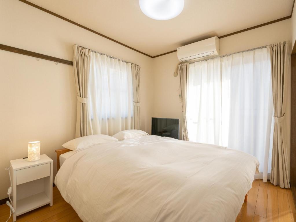 东京maison elegance - Vacation STAY 15799的卧室配有白色的床和窗户。