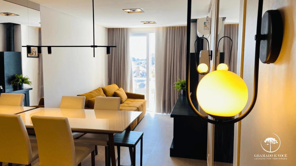 卡内拉Apartamento Novo Aconchegante e Moderno em Canela的客厅配有桌子和黄灯