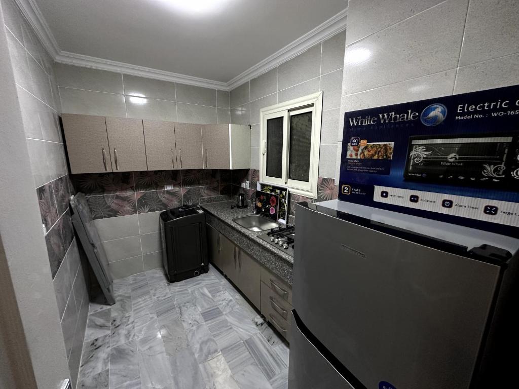 开罗شقة فندقية 108的一间带冰箱和水槽的小厨房