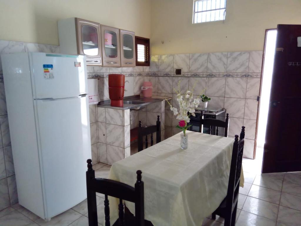 巴雷里尼亚斯Aconchego da Vó的厨房配有桌子和白色冰箱。