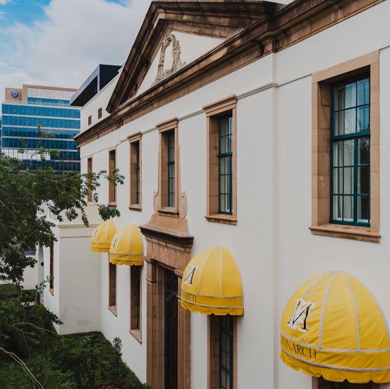 约翰内斯堡The Monarch Hotel的建筑的侧面有黄色的伞