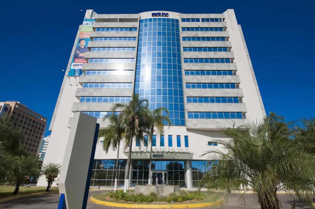 巴西利亚512. Flat hotel Go Inn的一座高大的建筑,前面有棕榈树