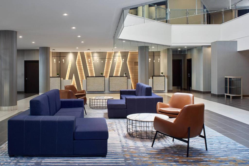 萨斯卡通Delta Hotels by Marriott Saskatoon Downtown的大堂设有蓝色的沙发和桌椅