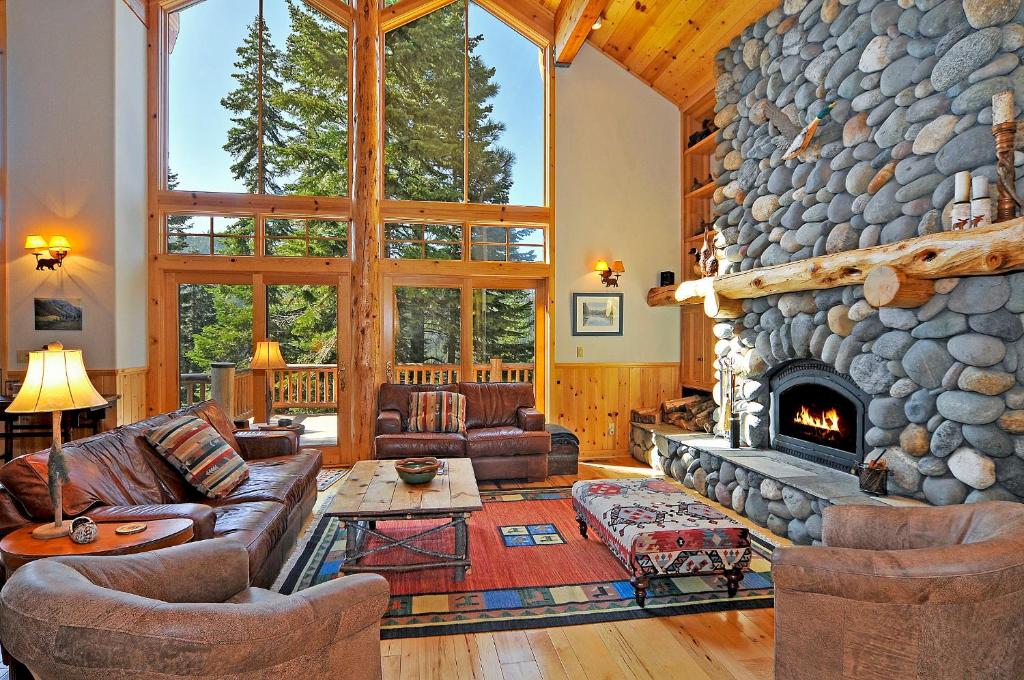 奥林匹克谷Sierra Crest at Palisades Tahoe - Secluded Luxury 5BR 5 BA w Wood Fireplace的客厅设有大型石制壁炉