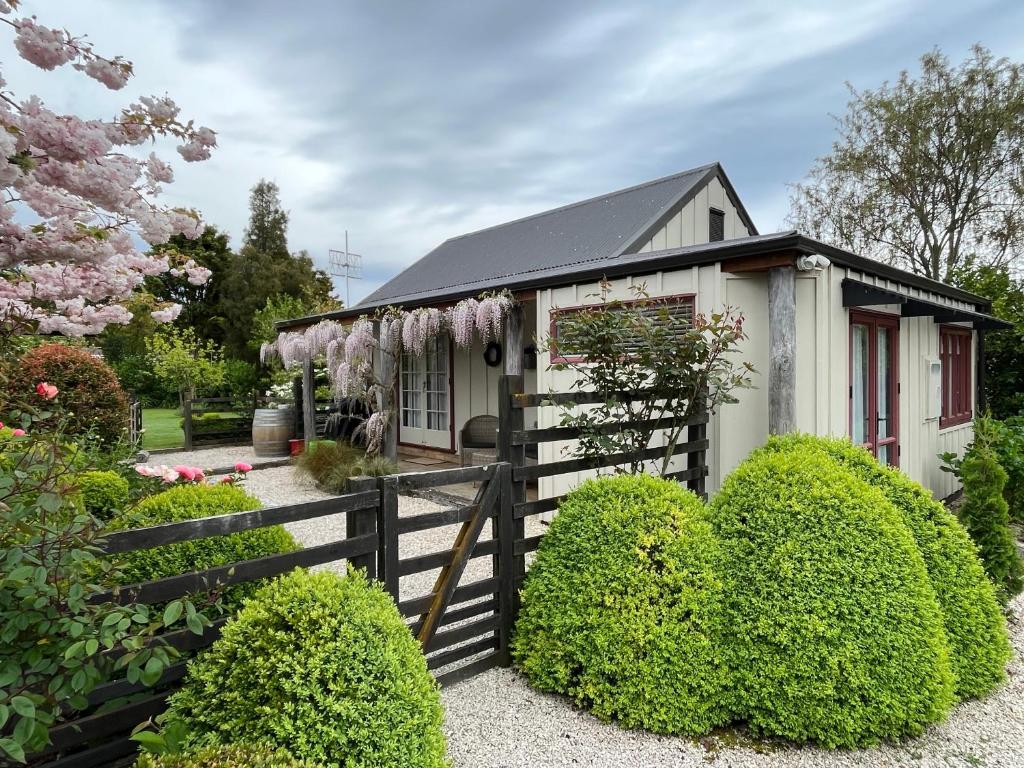 TasmanTasman Village Cottage的一座带围栏和鲜花的小房子