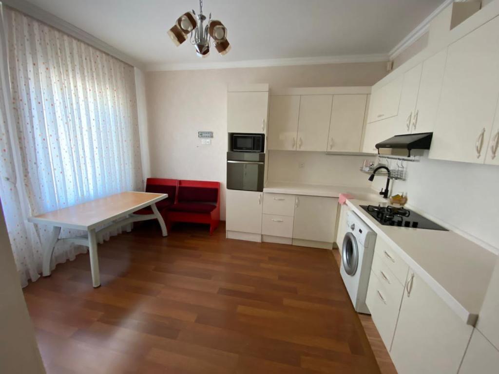巴库Bakı, Shagan Villa的厨房配有白色橱柜、桌子和水槽。