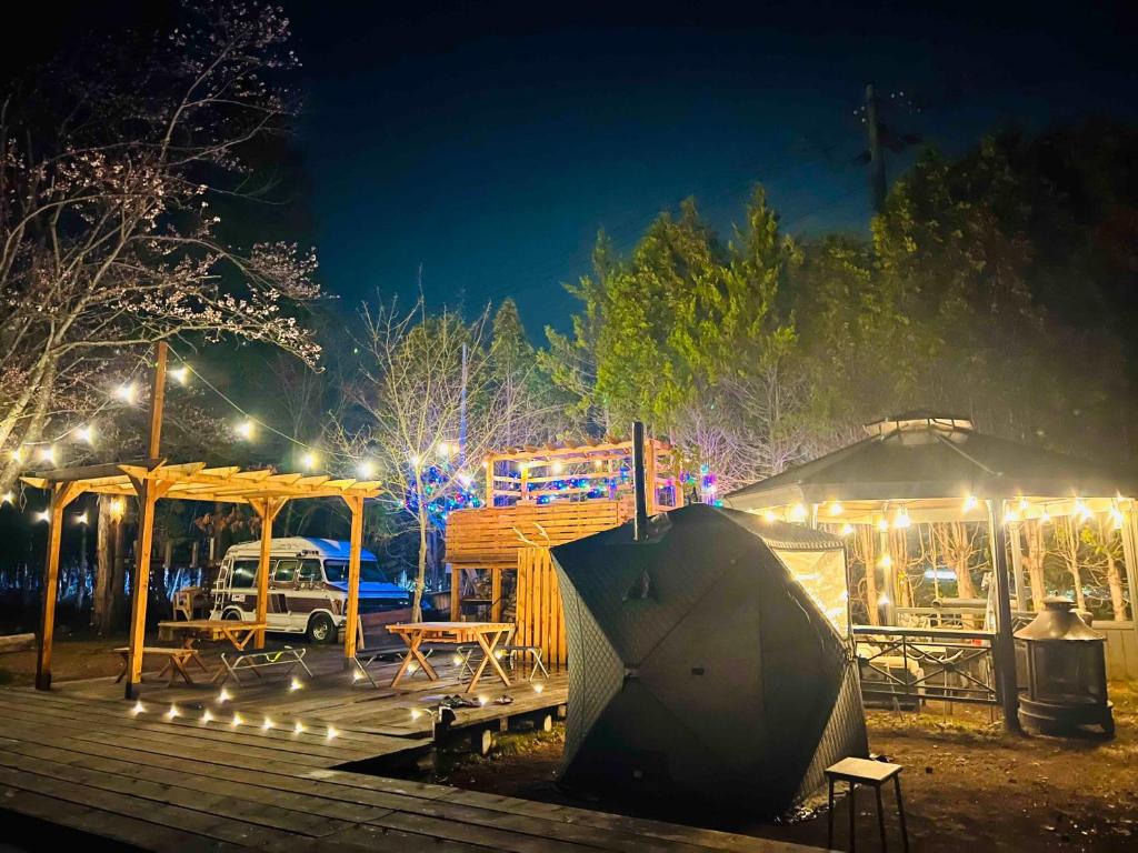 Eniwaキャンパーズエリア恵庭 TCS Village的公园里晚上有帐篷和灯