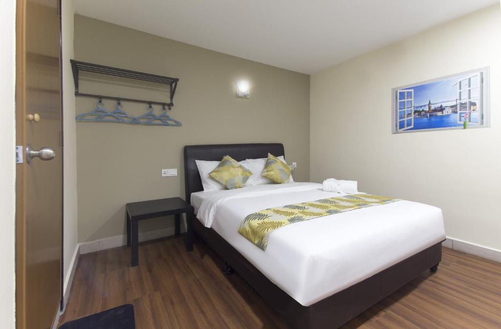 吉隆坡Hotel Sunjoy9 @ Mid Valley的卧室配有一张带黄色枕头的大型白色床。