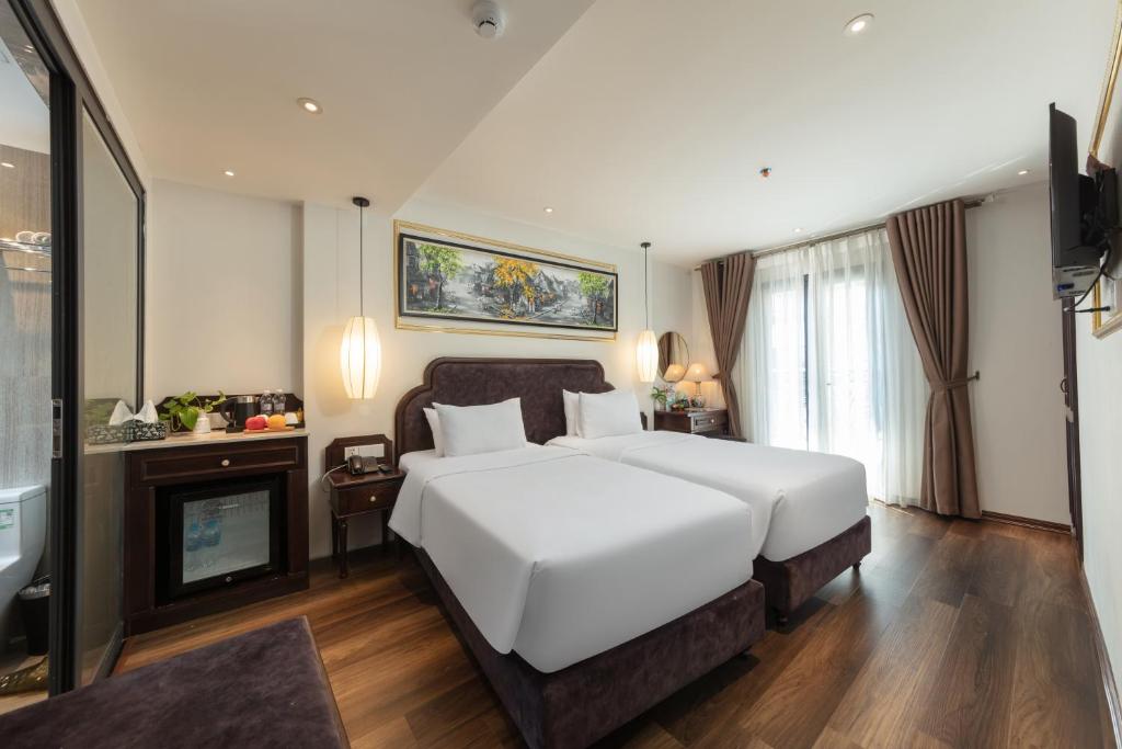 河内Hanoi Calista Hotel的卧室配有一张白色大床和壁炉