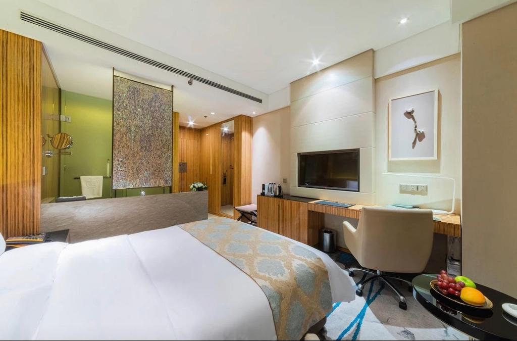 银川银川西府井饭店的酒店客房配有一张床和一张带电脑的书桌