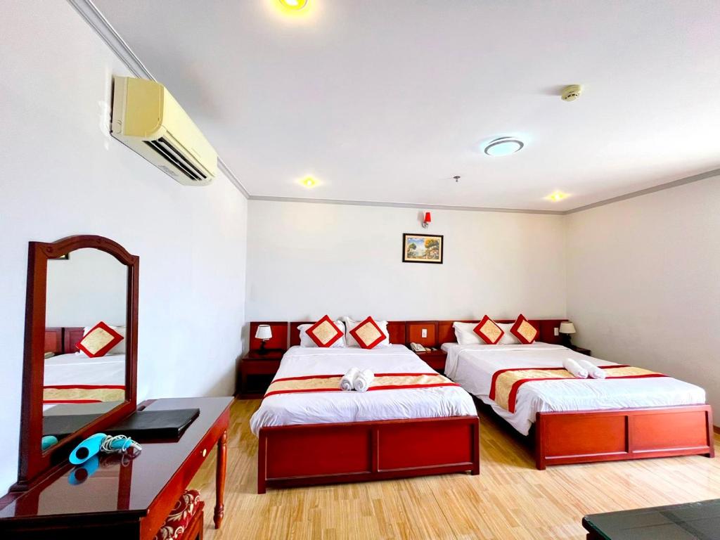 芹苴芹苴亚洲大酒店的一间卧室配有两张床和镜子