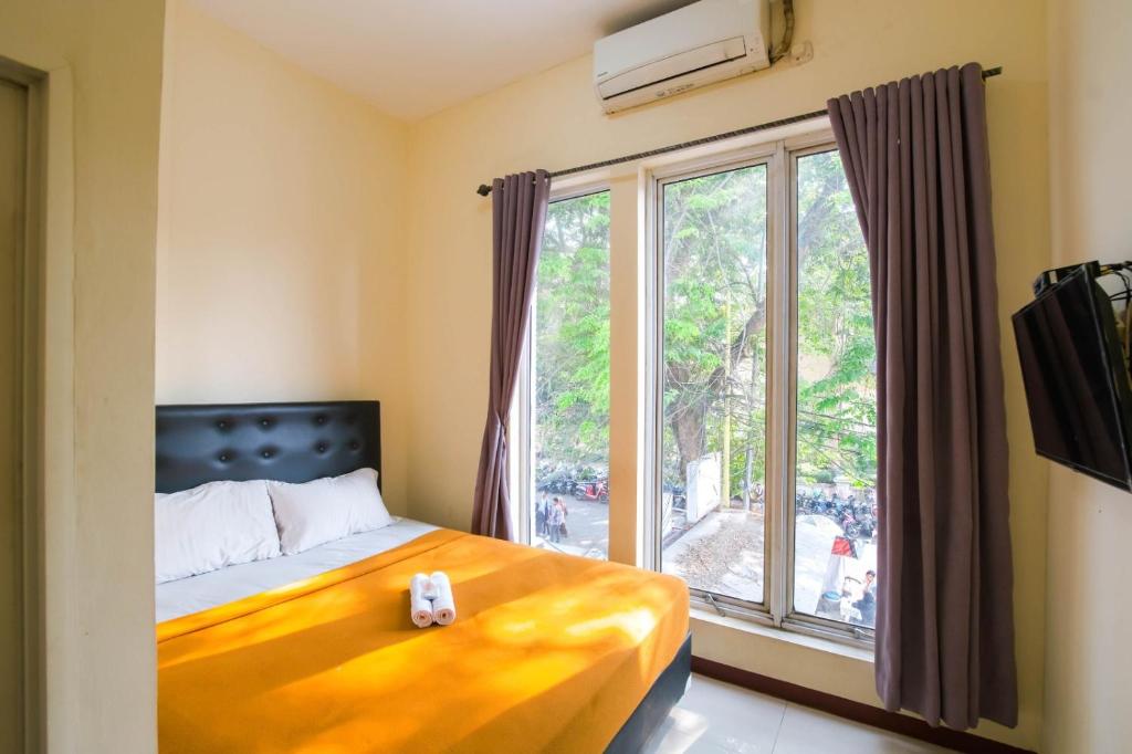 当格浪Athena Syariah Residence的一间卧室设有一张床和一个大窗户
