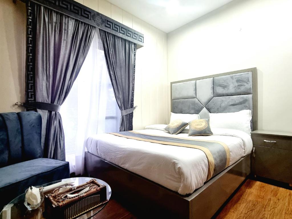 拉合尔Hotel Grand Pakeeza的一间卧室设有一张大床和一个窗户。