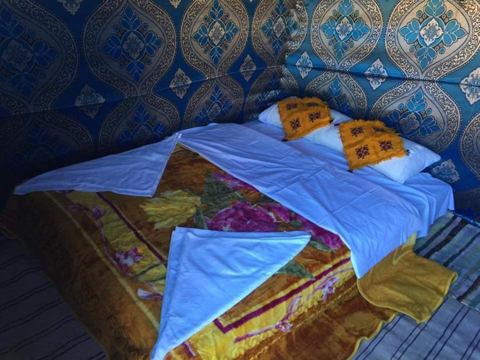 AdrouineHoneymoon Luxury Glamping的一张带蓝色被子和枕头的床