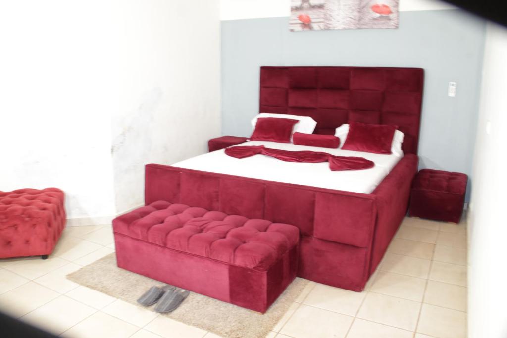 雅温得KRISTAL HOME的一间卧室配有红色的床和红色的沙发