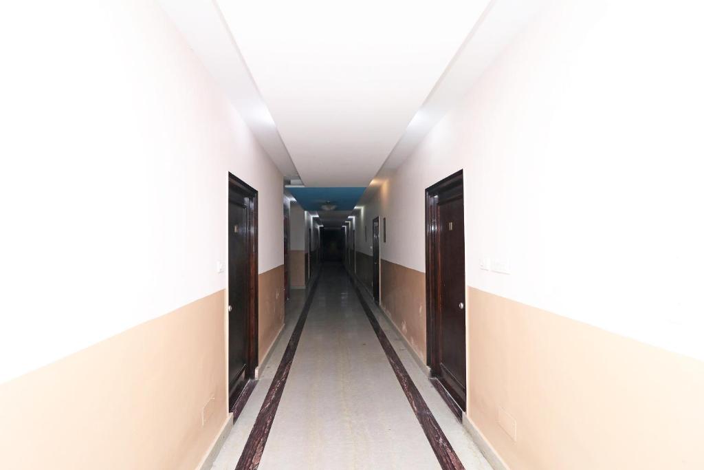 RāmpuraOYO 13161 Apni Havali Hotel & Restaurant的医院里空的走廊,门开