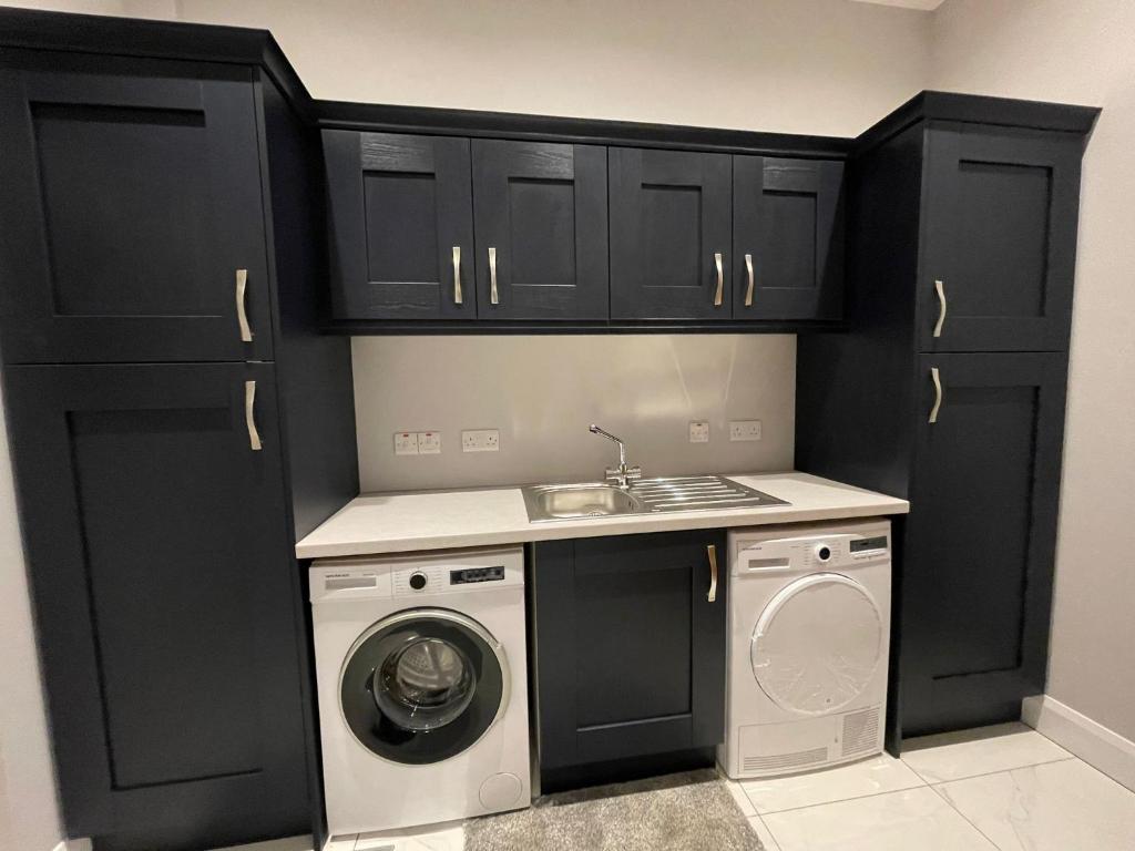 波塔当Boutique Villa - Room 1的厨房配有黑色橱柜和洗衣机。