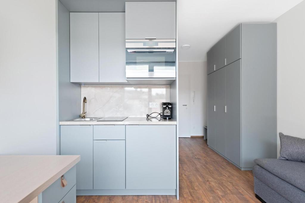 山麓布伦Schickes All-inklusive Apartmentzimmer by RESIDA Asset GmbH的厨房配有白色橱柜和沙发。