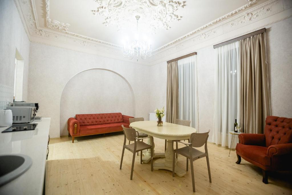 库塔伊西Moedani-Very Center Apartments in Kutaisi的客厅配有桌子和红色沙发