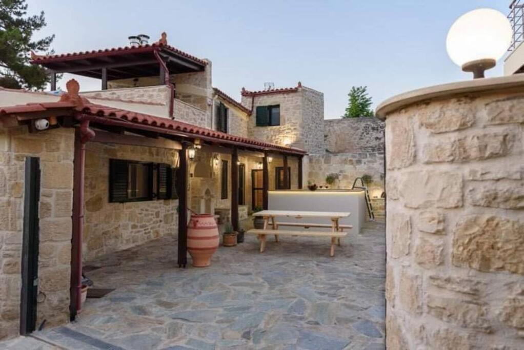海若克利欧Pyrgou Villa with Shared Swimming pool的一个带长凳的户外庭院和一座建筑