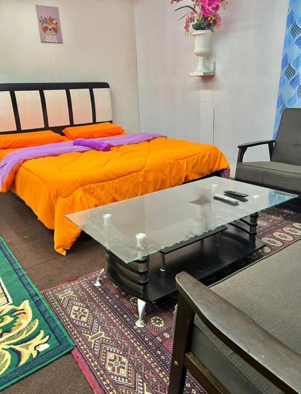 昆达桑MAK Room的一间卧室配有一张带玻璃桌和沙发的床