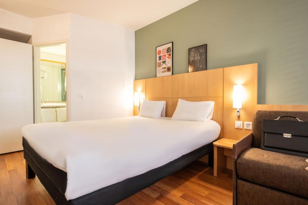 日内瓦日内瓦国家中心宜必思酒店的酒店客房带一张大床和一把椅子