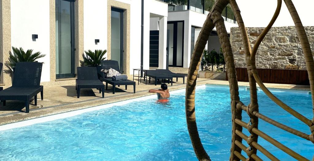 维拉·普拉亚·德·安科拉BLUE ANCORA HOTEL的一家酒店游泳池里的男人