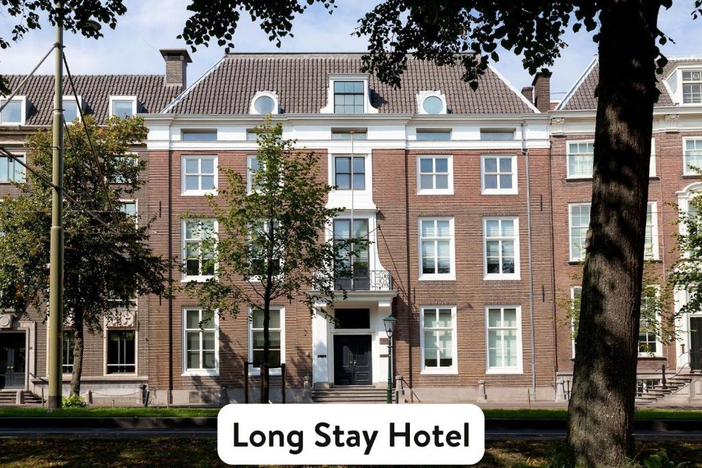 海牙Staybridge Suites The Hague - Parliament, an IHG Hotel的一座大型砖砌建筑,有着“长住”的字眼