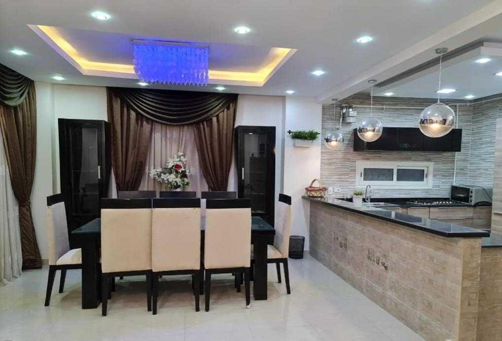 达赫拉Appartements de luxe à Al Mahdi的一间带桌子的用餐室和一间厨房
