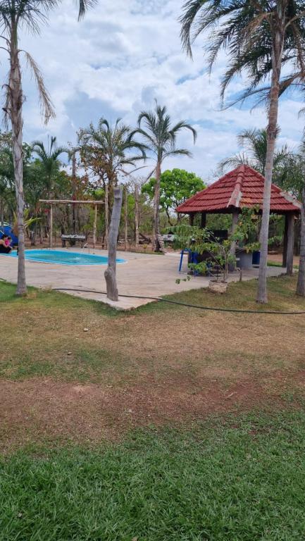 诺布里斯pousada camping do josias的一个带游泳池、凉亭和棕榈树的度假村