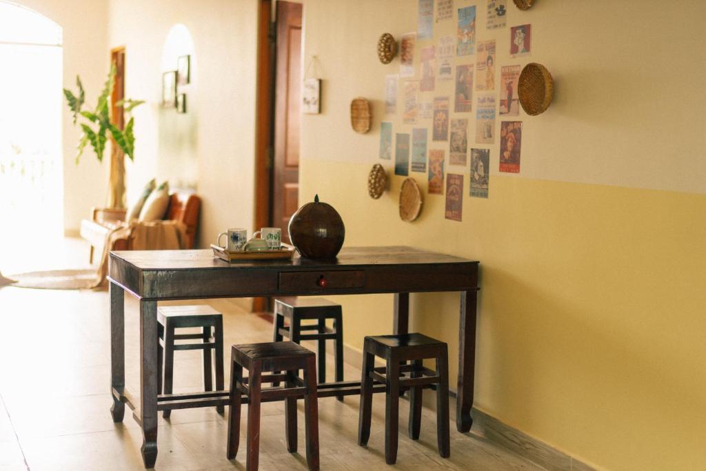 槟知Entire House - Nhà nguyên căn - Nhà Mơ Homestay Bến Tre的一张桌子和四把凳子在房间里