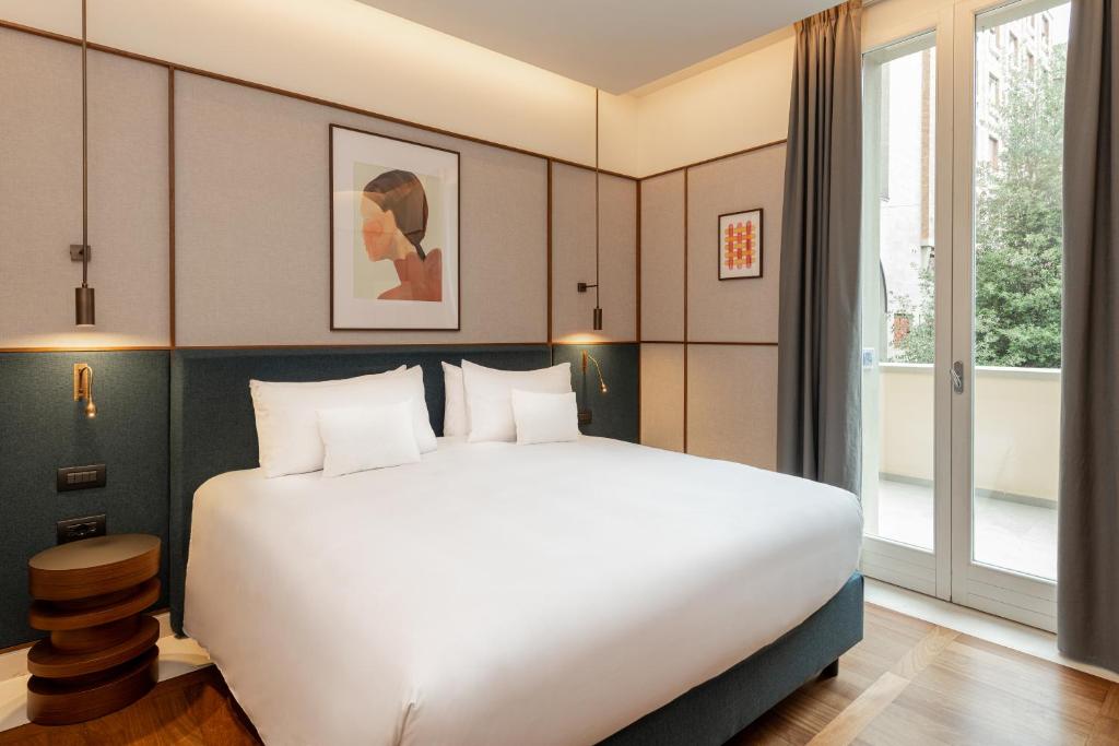 博洛尼亚Hotel Brun的卧室设有一张白色大床和一扇窗户。