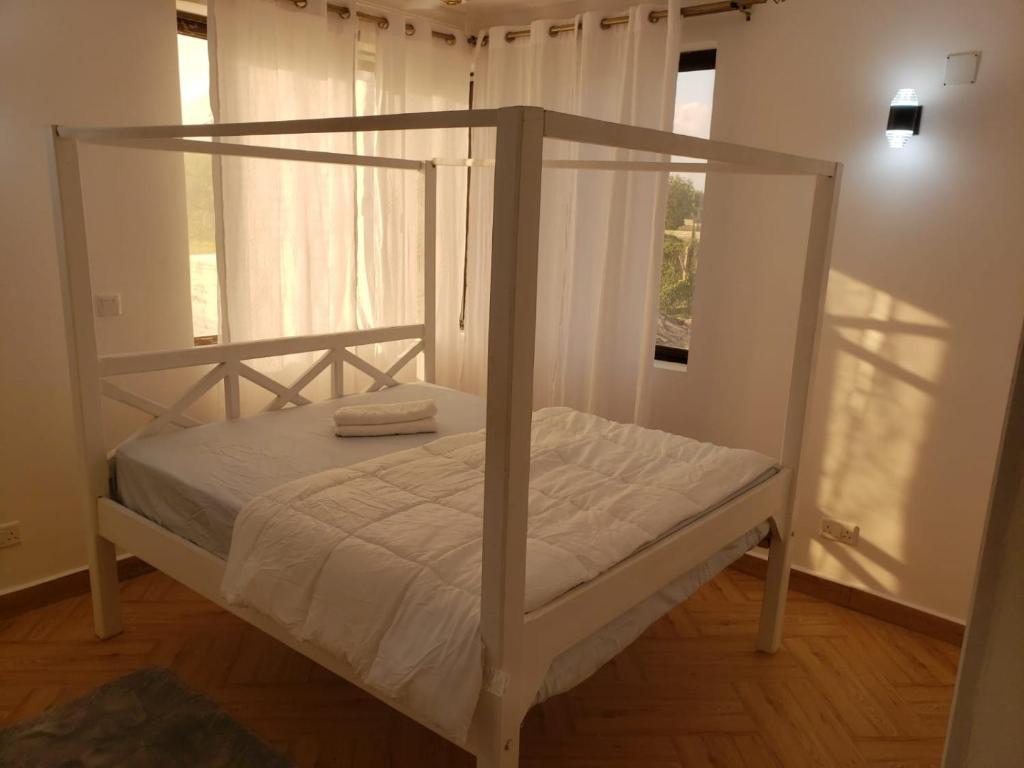 迪亚尼海滩Casa Marabella A2的客房内的白色床和天蓬