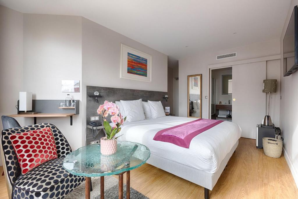 巴黎法兰西因瓦里德酒店的酒店客房设有一张床铺和一张玻璃桌