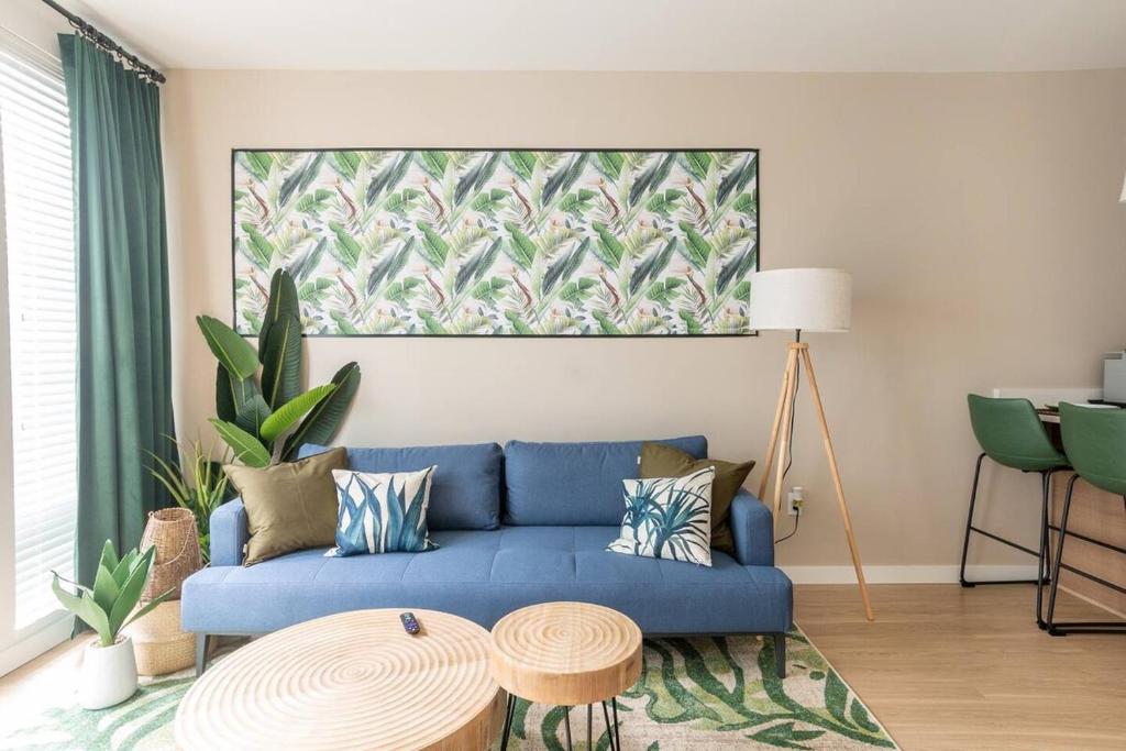 塔科马Palm Theme King Bed Paid Garage 55" 4k Smart T的客厅配有蓝色的沙发和桌子