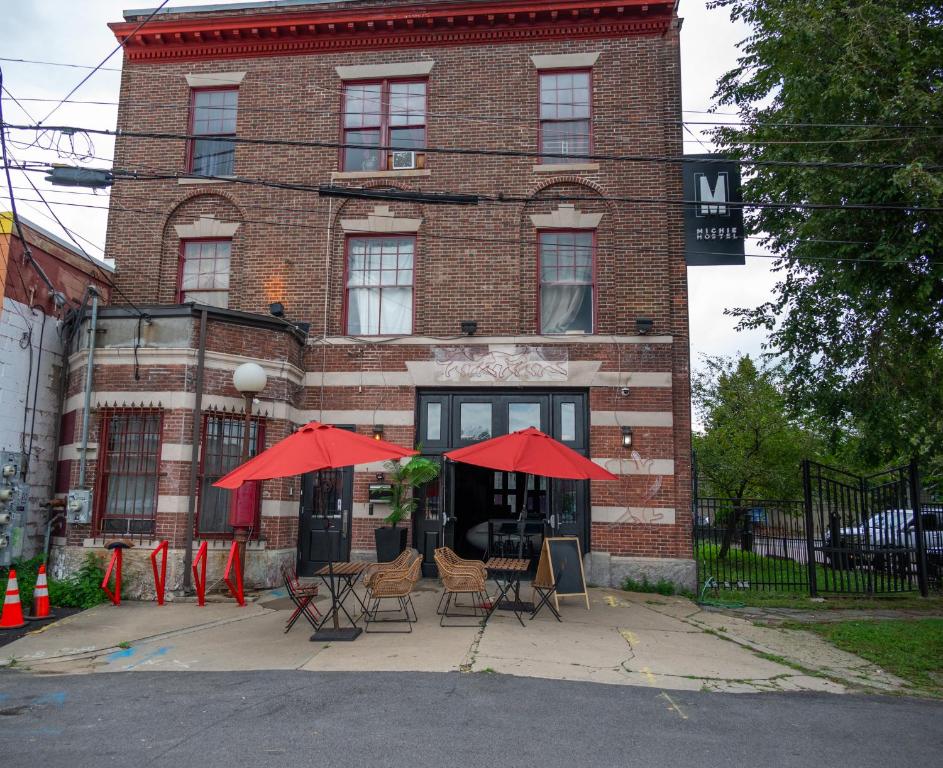 普罗维登斯Michie Hostel的前面有椅子和红伞的建筑