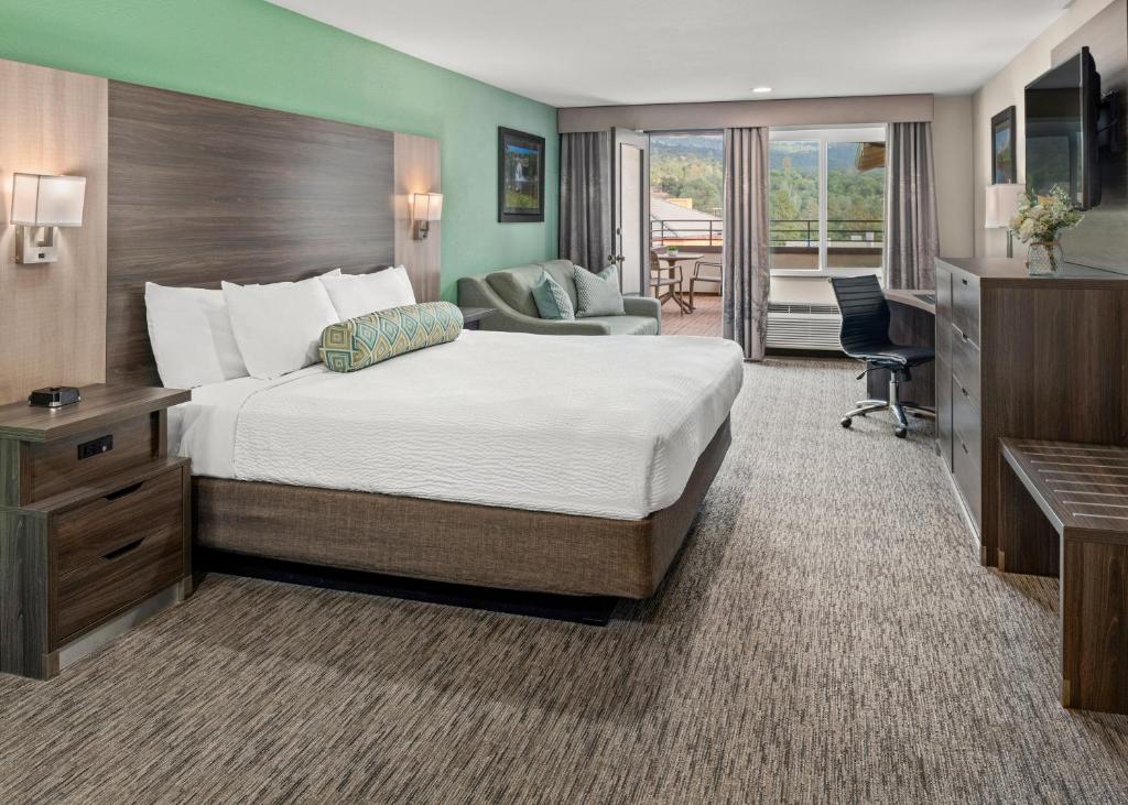 奥克赫斯特优胜美地南门套房酒店的酒店客房设有一张大床和一张书桌。