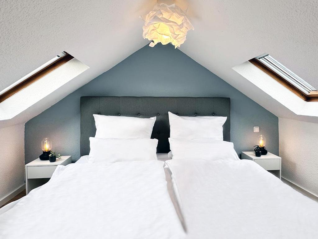 门兴格拉德巴赫Modernes City-Apartment in Mönchengladbach的一间卧室配有一张带2个床头柜的大型白色床