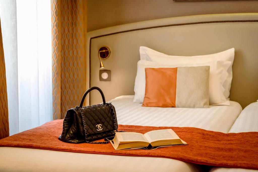 巴黎贝斯特韦斯特特洛加德洛酒店的一张带袋子、书和钱包的床