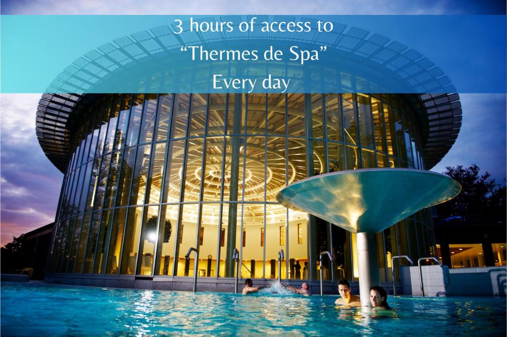 斯帕Les Thermes de Spa by La Cour de la Reine Hôtel, Suites & accès gratuit au centre thermal的建筑前的一座带游泳池的建筑