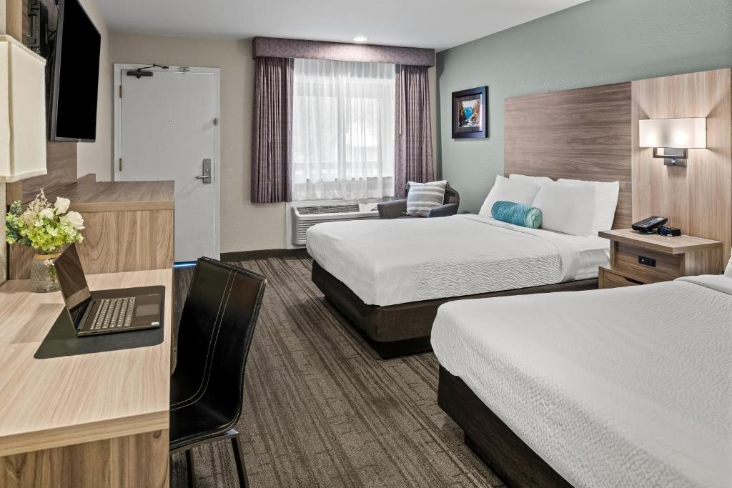 格罗夫兰优胜美地西门旅舍的酒店客房配有两张床和一张带笔记本电脑的书桌