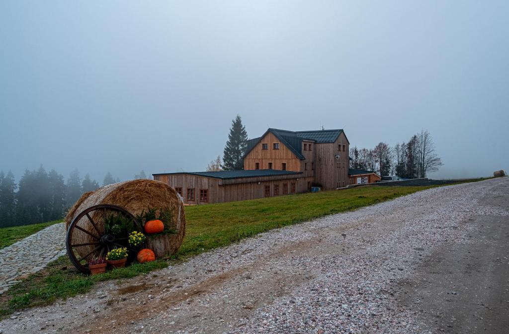 切尔尼杜尔Horská bouda Krakonoš的房屋旁的土路上的干草车