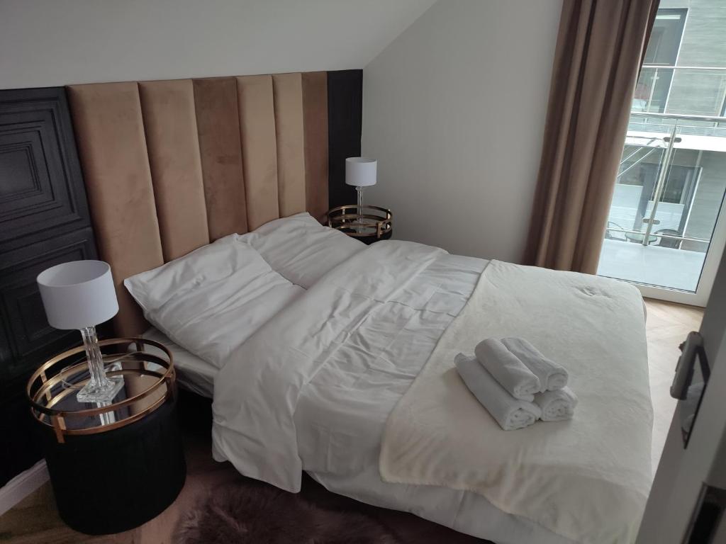 济夫努夫Golden Cliff HorizonPark Dziwnòwek的一张带白色床单的床和两张毛巾