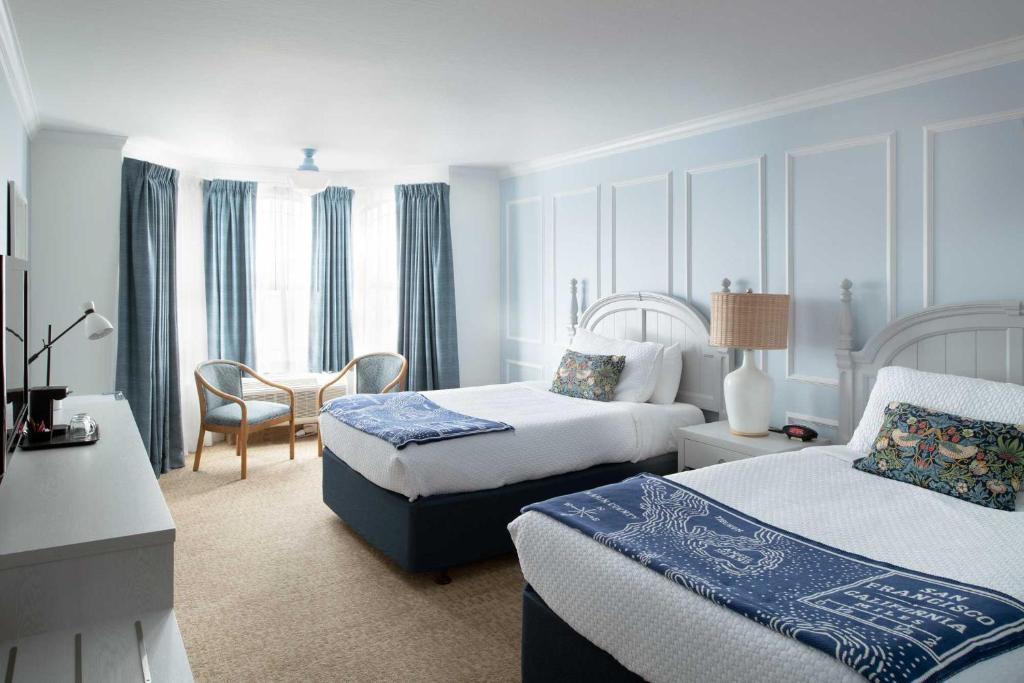 旧金山Coventry Motor Inn的酒店客房设有两张床和一张桌子。