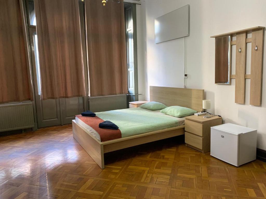 布达佩斯Kecskeméti Rooms的一间卧室配有一张床,铺有木地板
