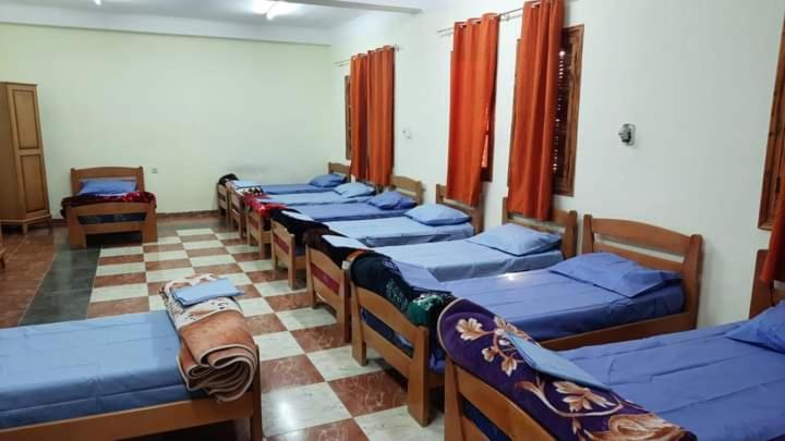 Bordj LutaudYouth hostel ouargla的一间房间里有一排床的房间