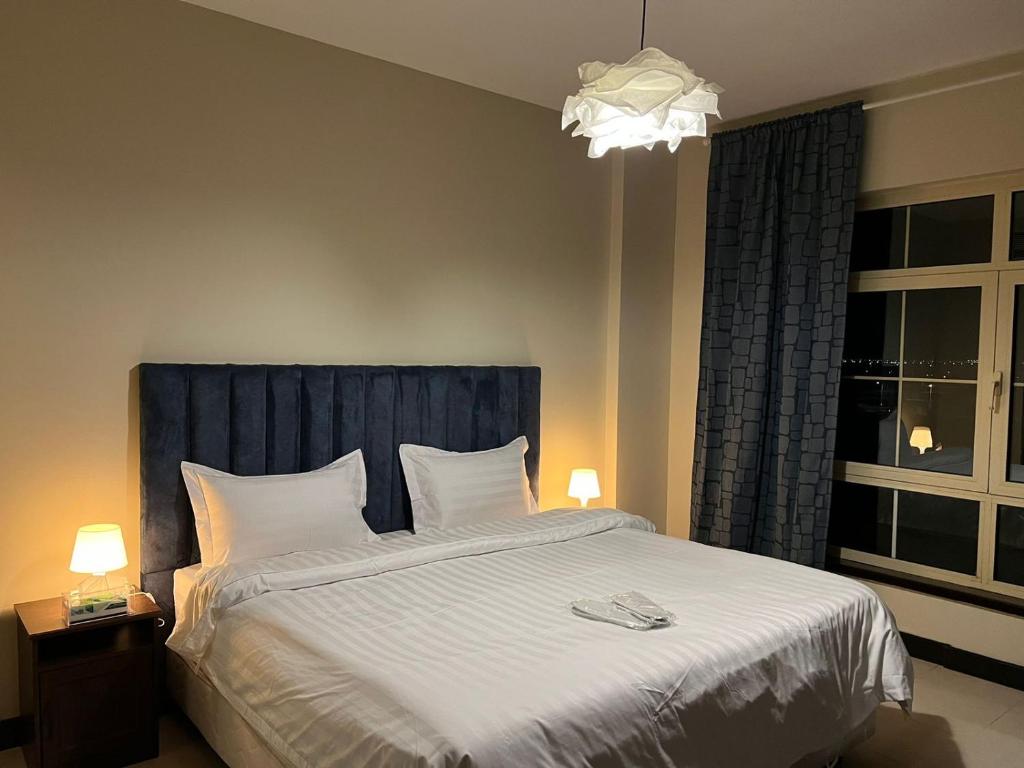 阿卜杜勒国王经济城هافانا المارينا Apartment的一间卧室配有一张大床和蓝色床头板