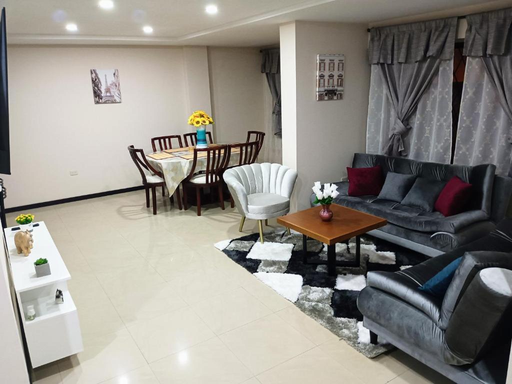 昆卡Departamento Grande con Jacuzzi的客厅配有沙发和桌子