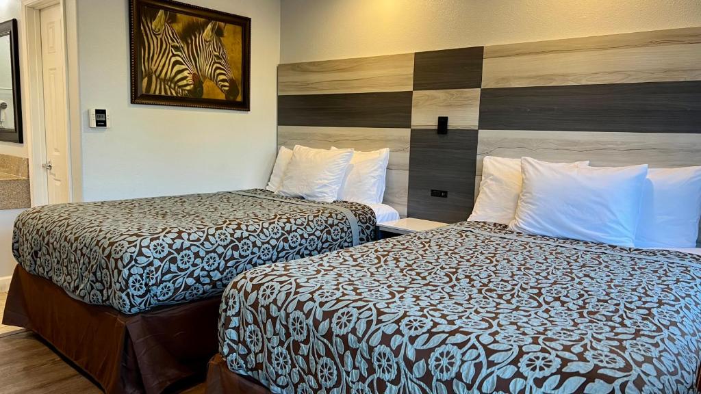 奥克兰清风湾酒店的酒店客房设有两张床,墙上挂有绘画作品