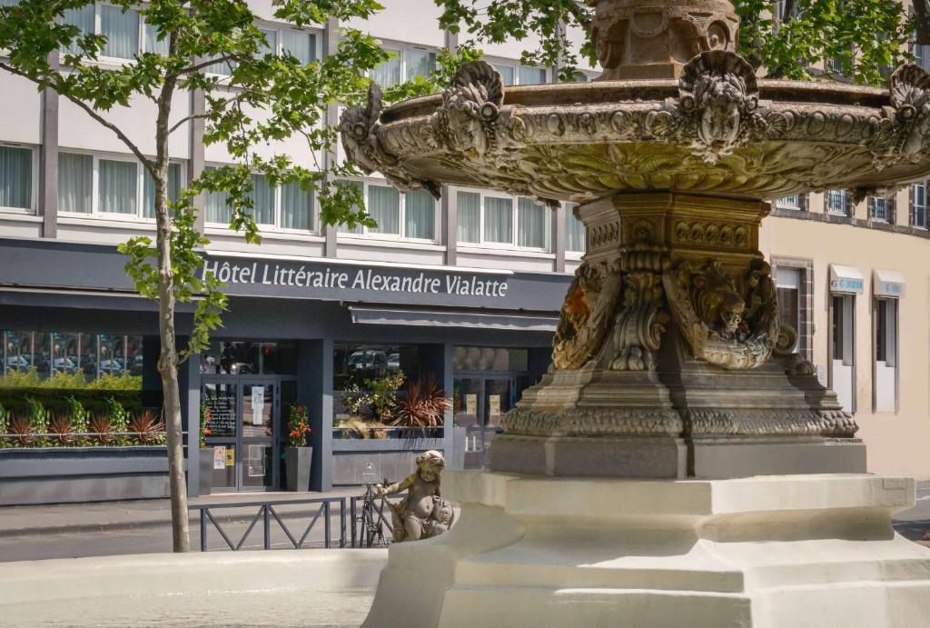 克莱蒙费朗Hotel Litteraire Alexandre Vialatte, BW Signature Collection的一座建筑物前喷泉的雕像